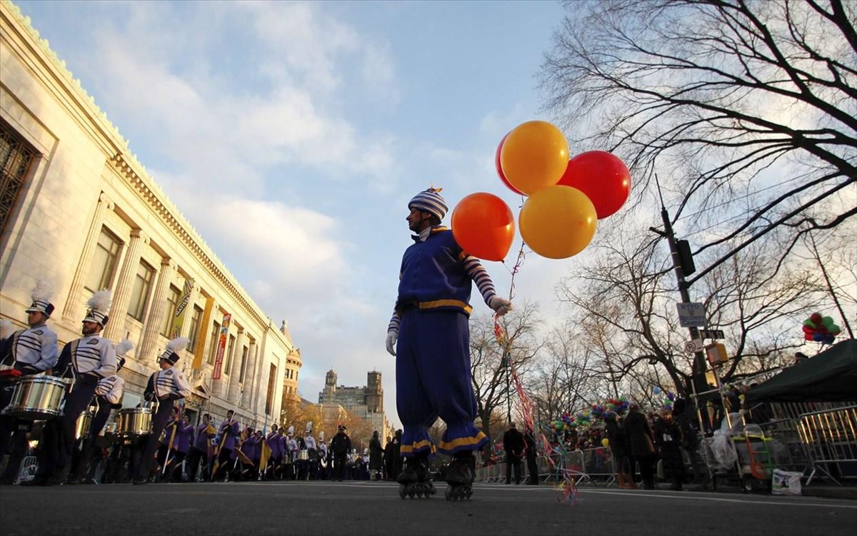 a-clown-hands-out-balloons-before-the-start-of-the-87th-macys-thanksgiving-day-parade-in-new-york
